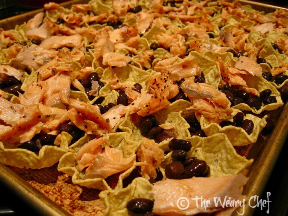 Now, spread the shredded salmon evenly over the nachos.