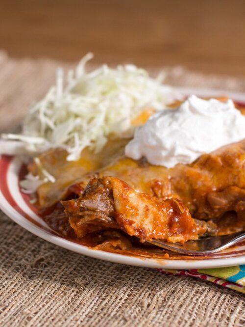 These delicious enchiladas are made easy with 2-ingredient slow cooker shredded beef!