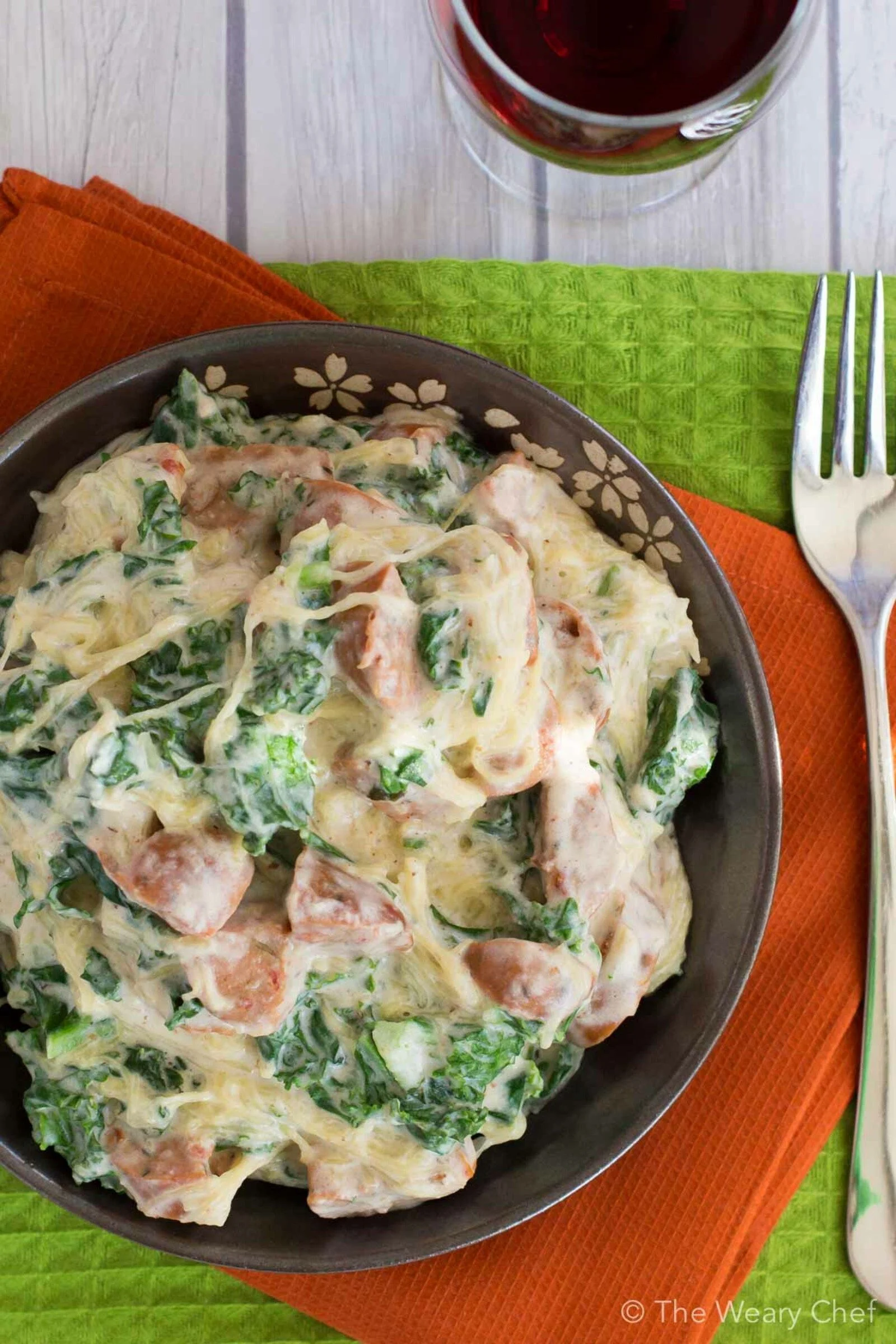 This healthy sausage alfredo recipe uses no cream and is served over spaghetti squash instead of pasta!