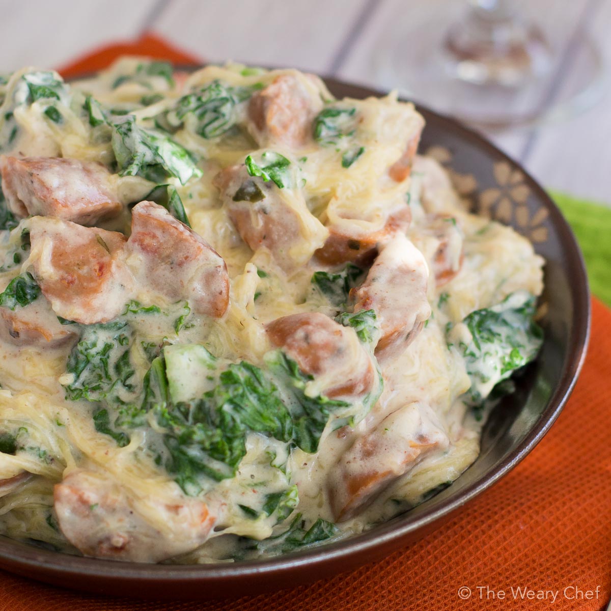 This healthy sausage alfredo recipe uses no cream and is served over spaghetti squash instead of pasta!