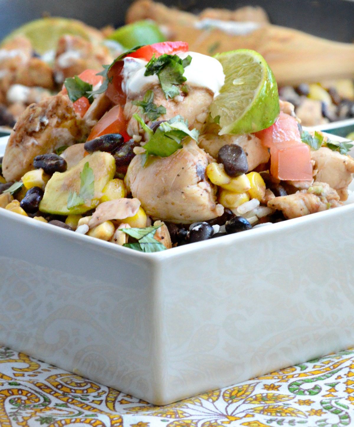 This 30-minute meal features Chipotle Lime Chicken stir fried with black beans and corn. Top it with avocado, tomato, and sour cream for a beautiful finish!