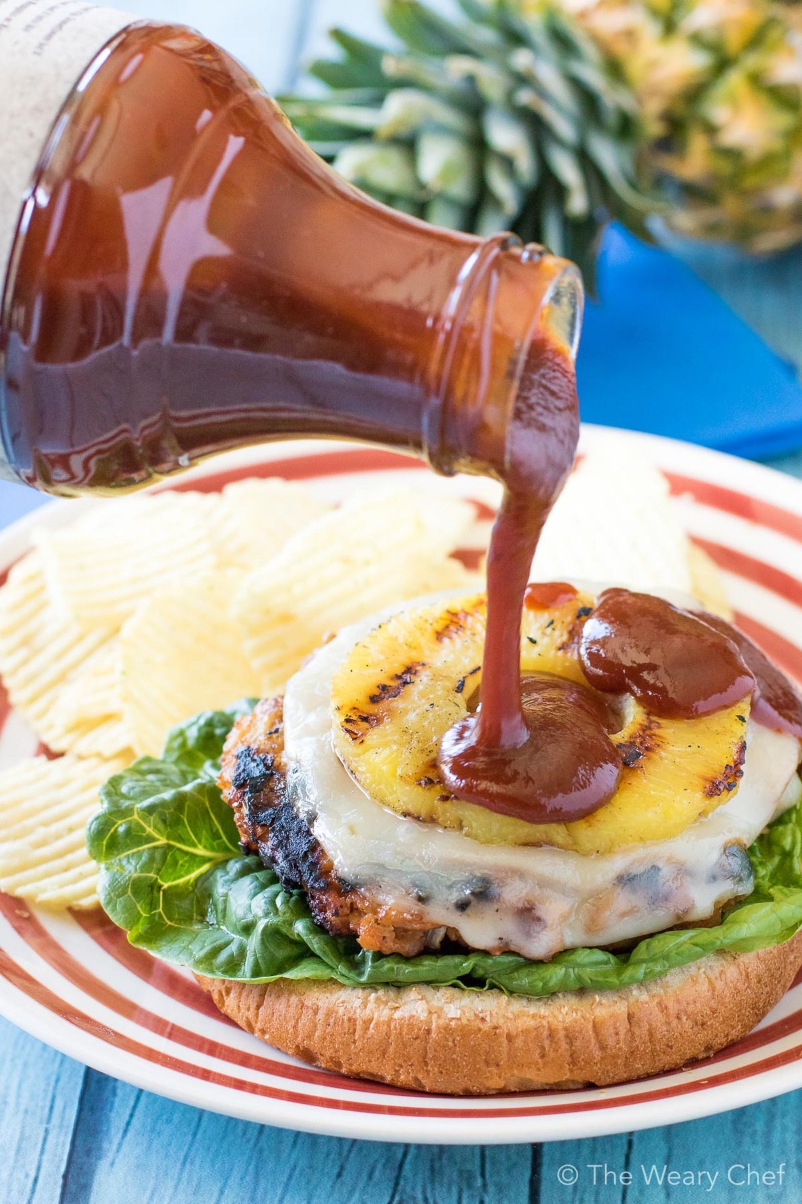 These sweet and savory Hawaiian Chicken BBQ Burgers will take your cookout to the next level! Seasoned chicken burgers are topped with sliced ham, melted cheese, a pineapple ring, and a generous drizzle of BBQ sauce. The flavor is out of this world!