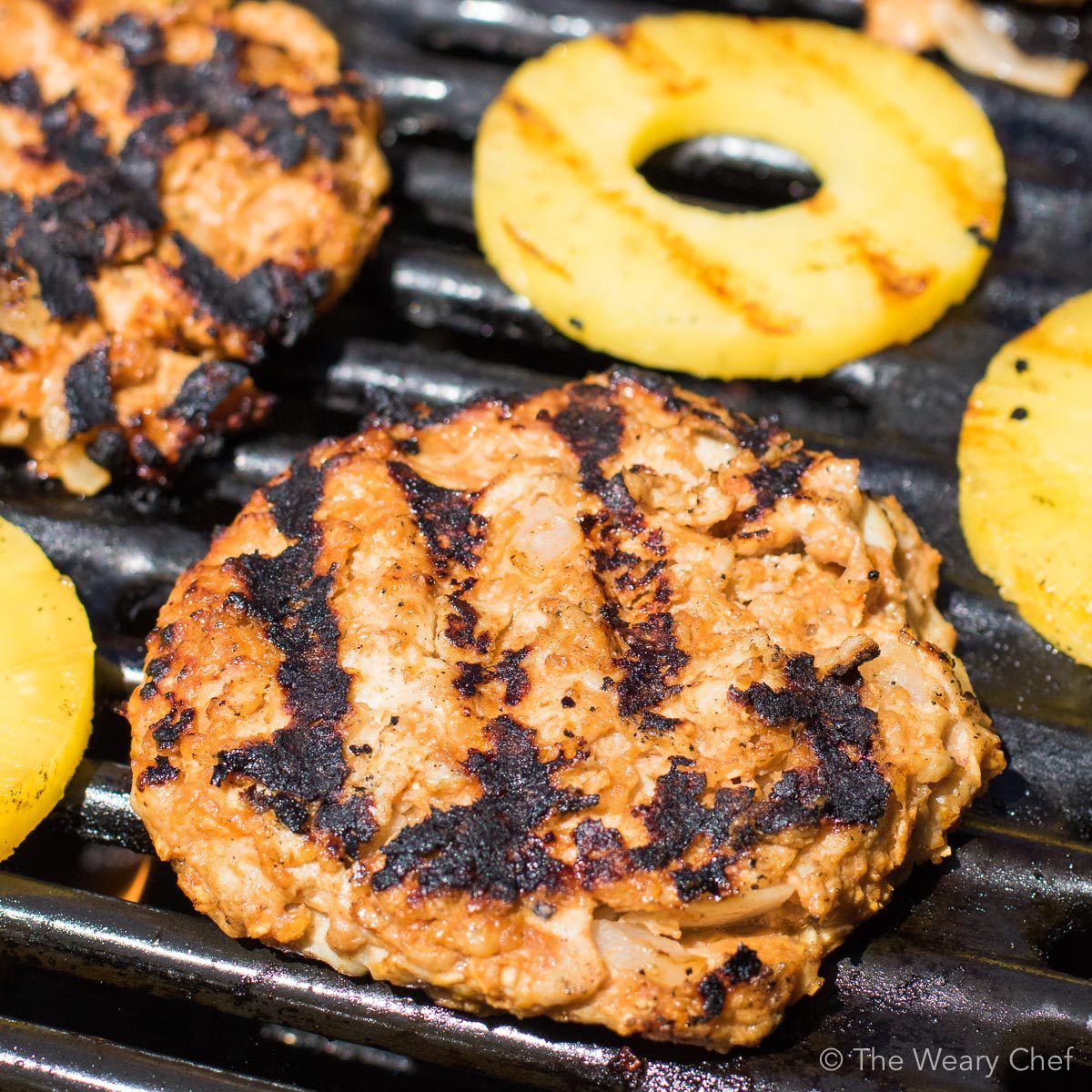 These sweet and savory Hawaiian Chicken BBQ Burgers will take your cookout to the next level! Seasoned chicken burgers are topped with sliced ham, melted cheese, a pineapple ring, and a generous drizzle of BBQ sauce. The flavor is out of this world!