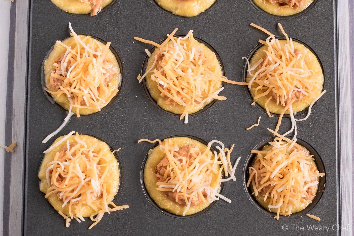 Mini cornbread muffins are stuffed with a creamy BBQ chicken mixture and topped with shredded cheese. Perfect easy recipe for tailgating, parties, and potlucks! #bbq #chicken #recipe