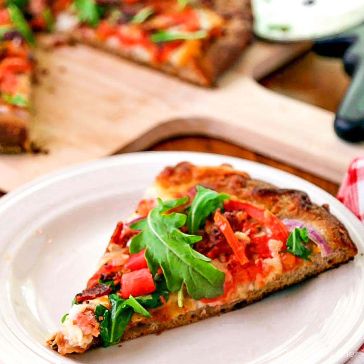 Bite into this BLT pizza loaded with a bacon, red onion, fresh tomatoes, arugula, cheeses, and a garlic-mayo sauce. It's your favorite sandwich turned into a chewy pizza! #blt #pizza #bacon