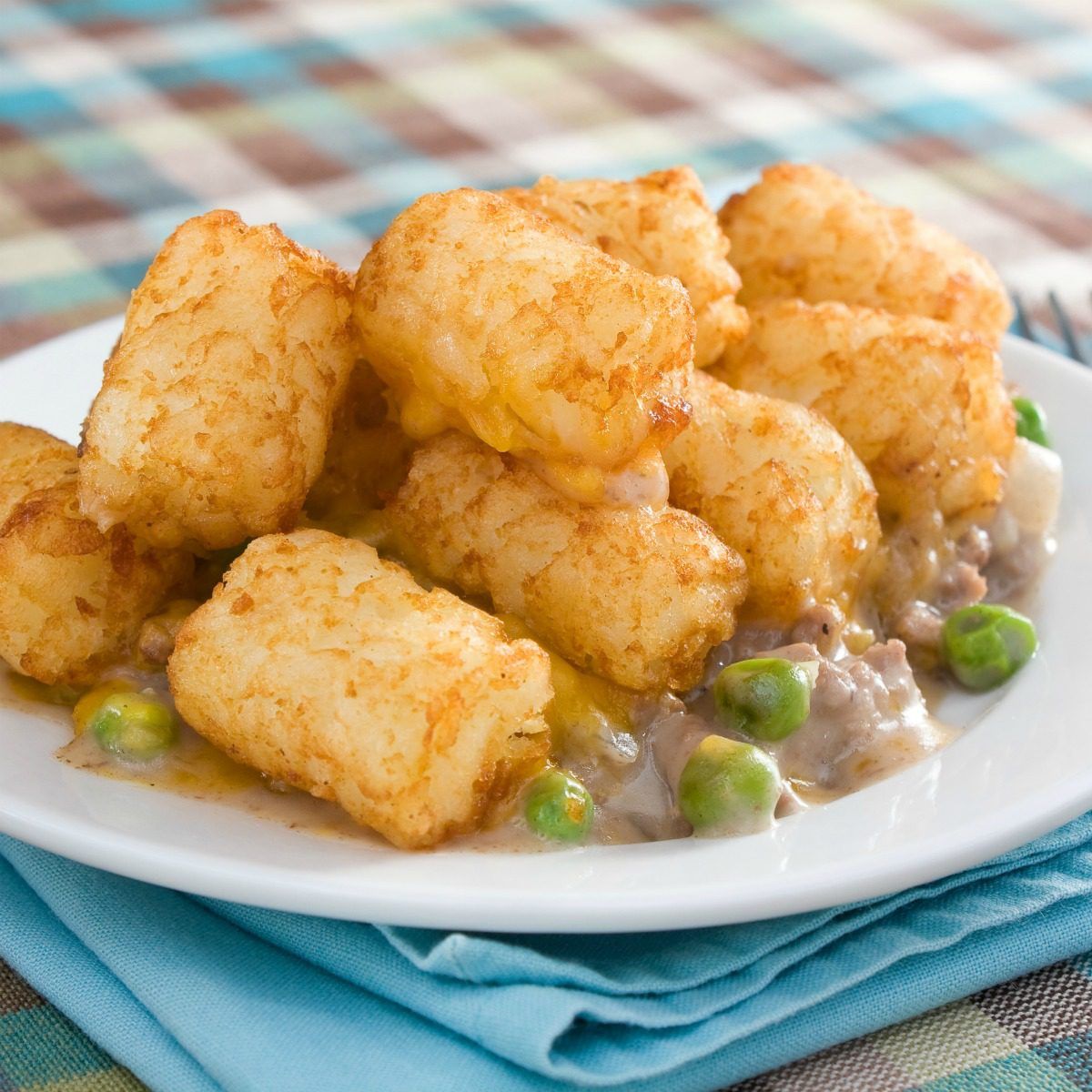 This easy Tater Tot Hot Dish is a perfect family dinner or potluck favorite. A hearty filling is topped with crispy tater tots for a truly comforting meal. #hotdish #casserole #tatertots