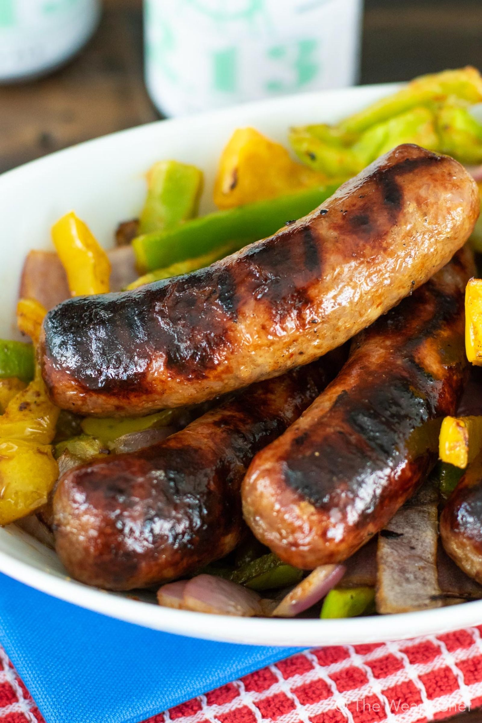 Grilled Sriracha Peppers and Onions with Sausages are an easy meal for summer entertaining! #grill #sausage #sriracha #spicy #peppers #thewearychef