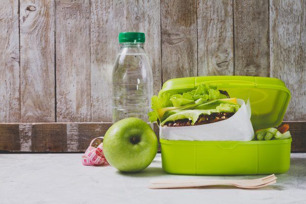 bottle of water , apple and lunchbox