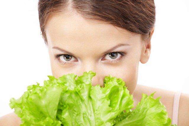 woman holding green vegetables