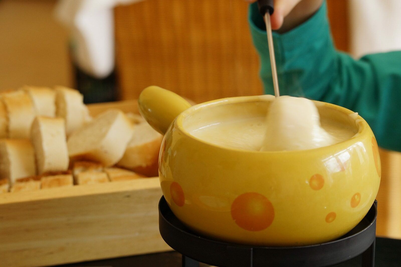 Person is mixing the Swiss cheese fondue in a pot 