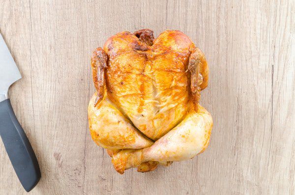 roasted turkey on a chopping board with knife at side