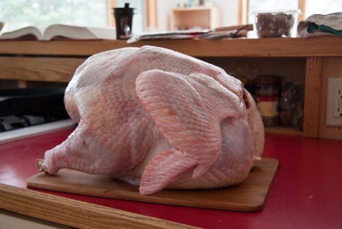 whole raw turkey on top of chopping board