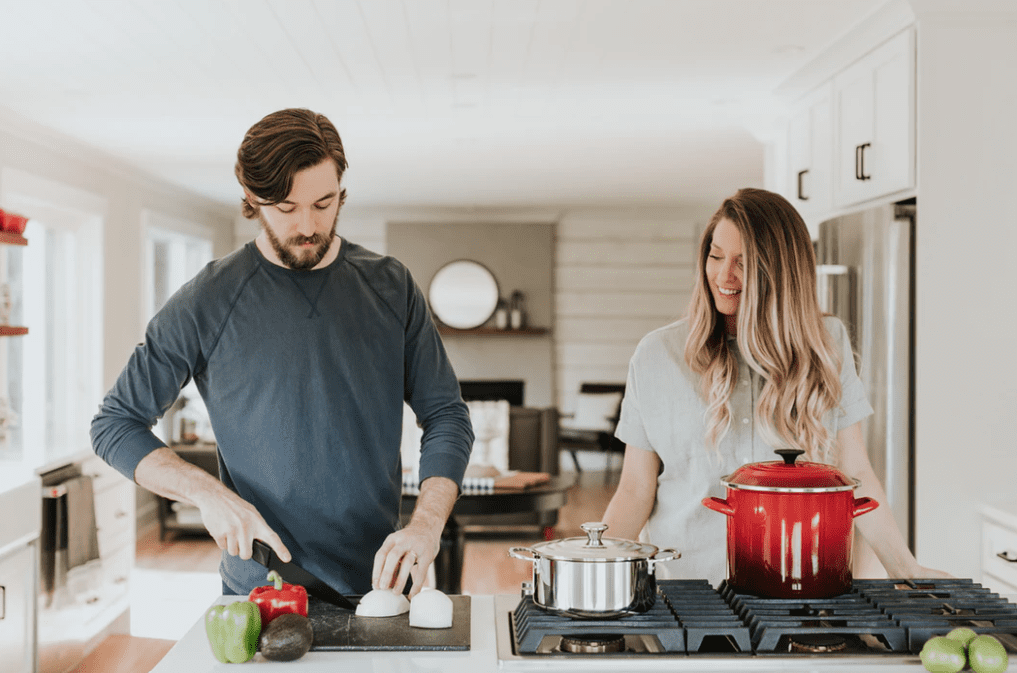 Couple chopping onions as an ingredient for classic spaghetti with meatballs 
