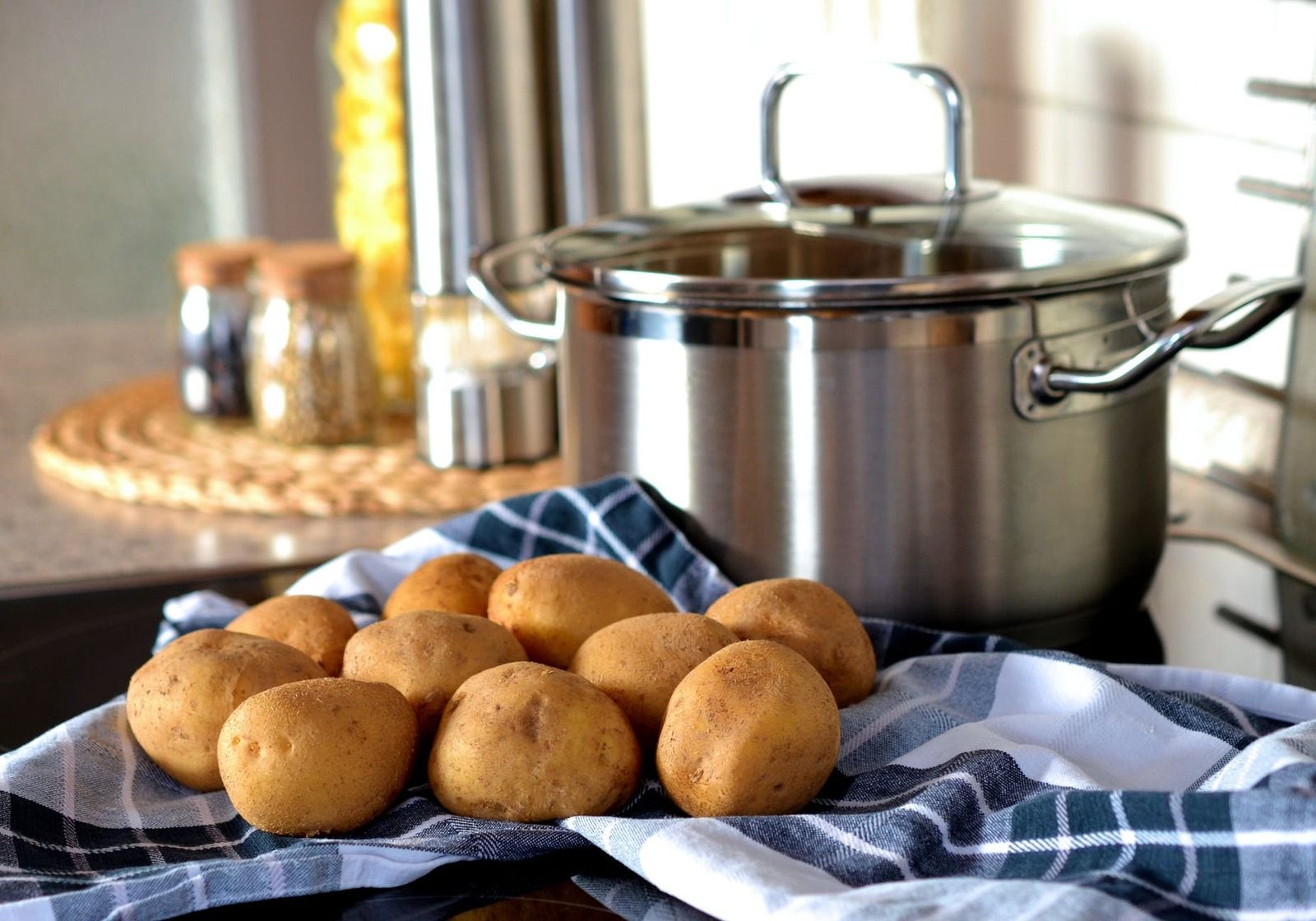 potatoes on a blue towel in front of a large pot