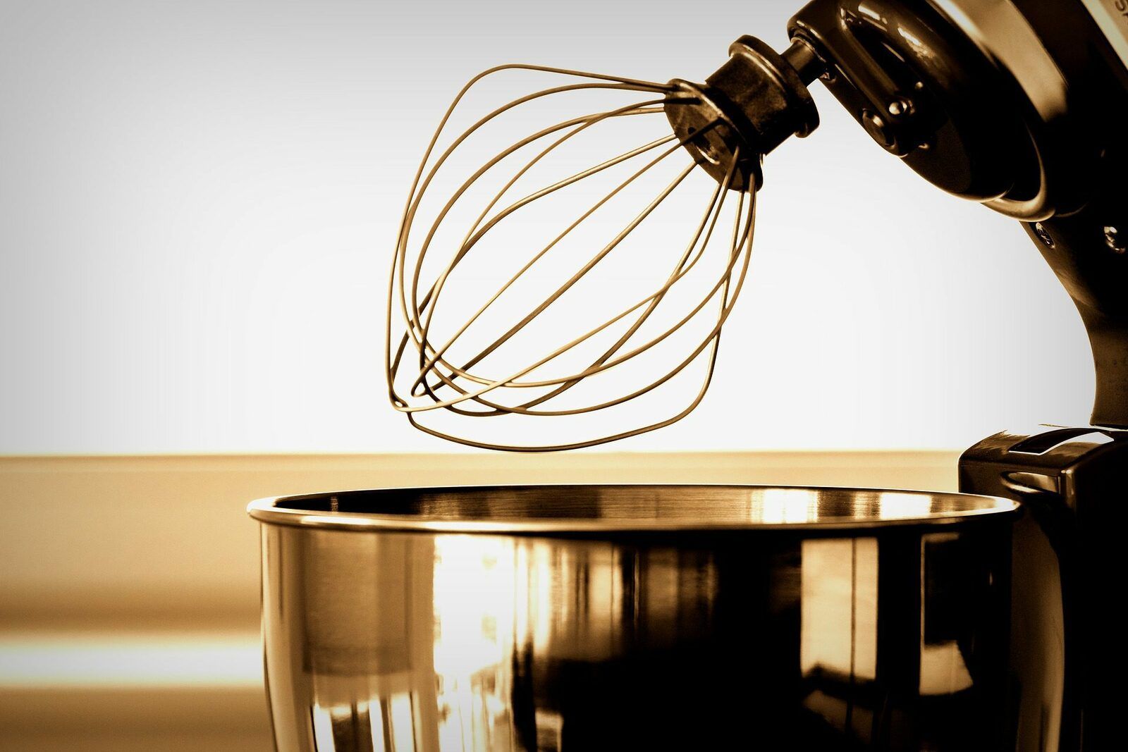 A standing cake mixer with a silver bowl