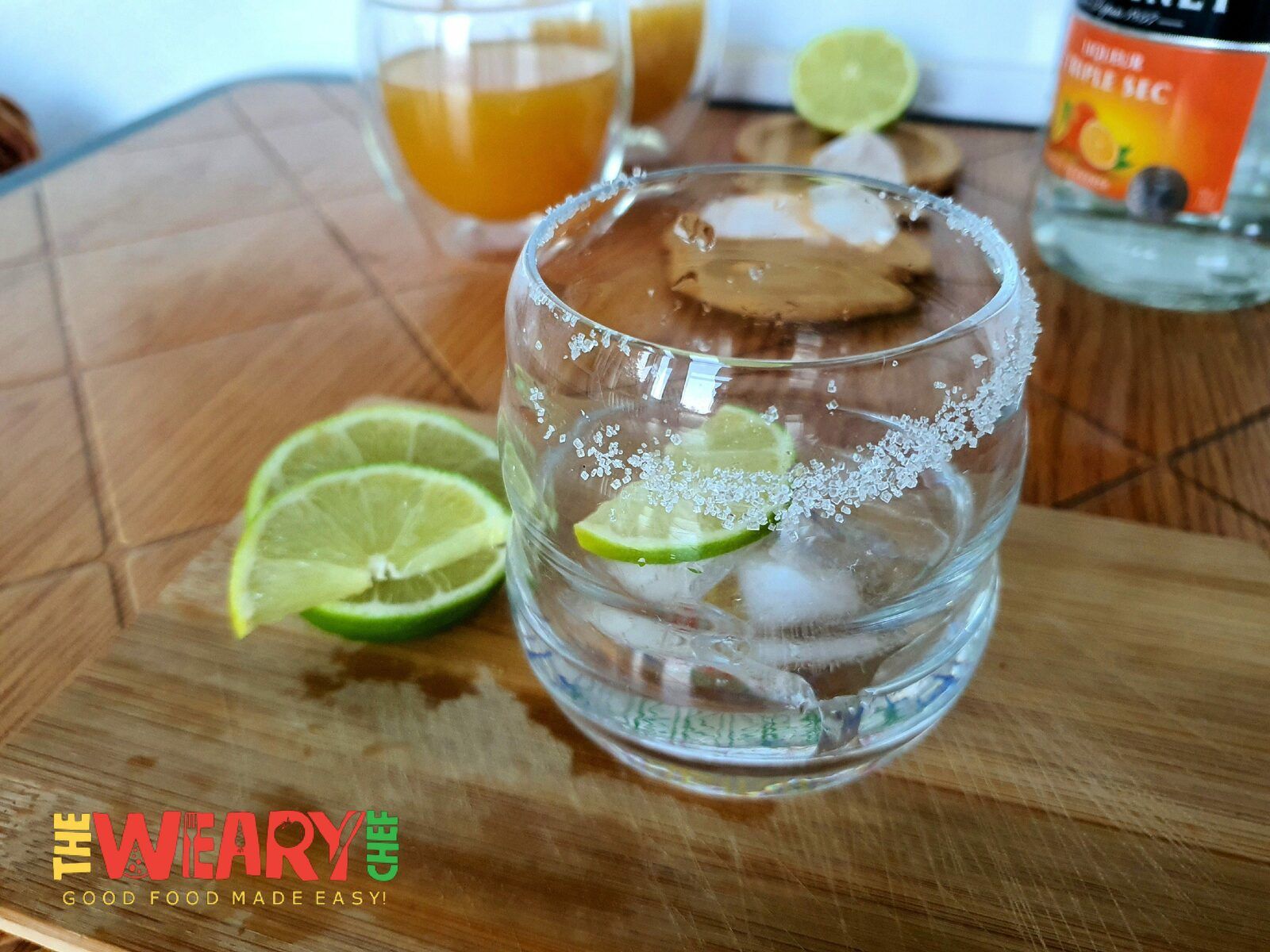 cocktail glass with lime and ice cubes